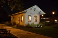 Photo of the Historical Itasca Depot in the dark with lights eluminating it
